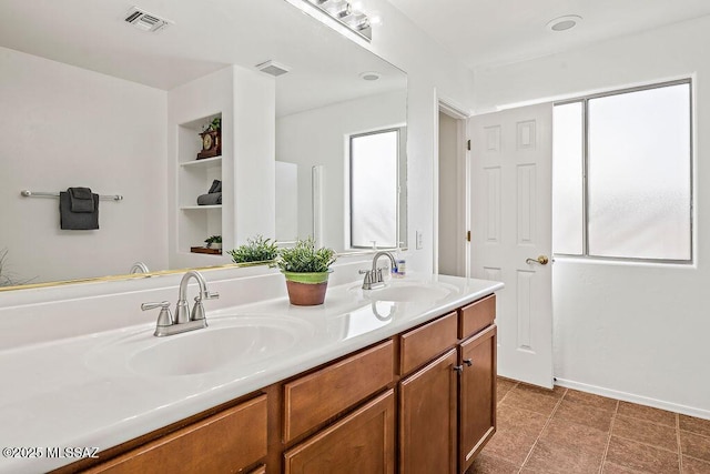 bathroom featuring double vanity, a sink, and visible vents