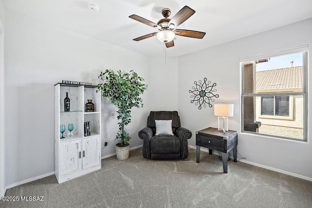 sitting room featuring baseboards, a ceiling fan, and carpet floors