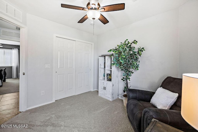 sitting room with a ceiling fan, visible vents, and carpet floors