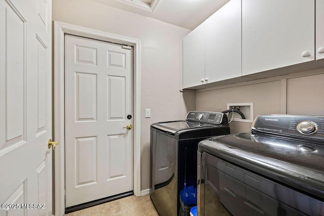 laundry room featuring light tile patterned flooring, cabinet space, and washer and clothes dryer