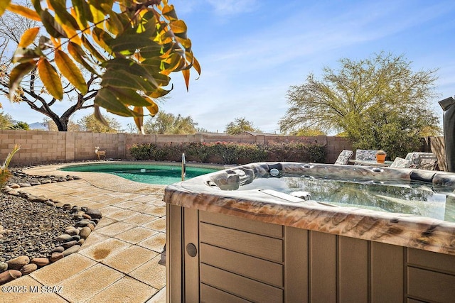 view of swimming pool featuring a fenced backyard, a patio area, and a hot tub