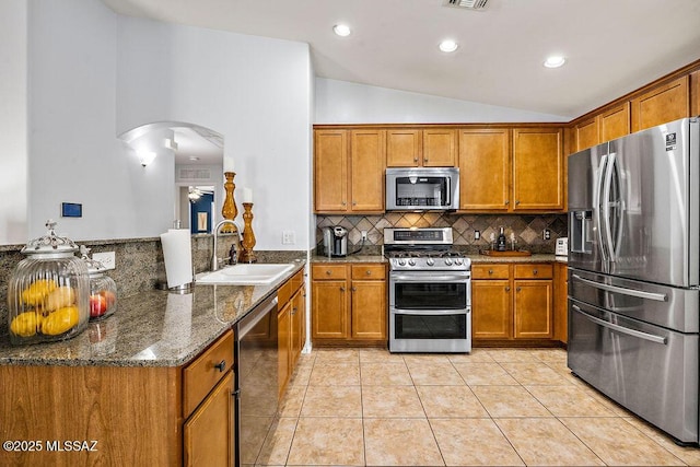 kitchen with brown cabinets, stainless steel appliances, and a sink