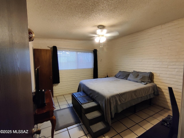 4016 E Fairmount St, Tucson, AZ 85712 - bedroom with light tile patterned flooring, a textured ceiling, ceiling fan, and brick wall