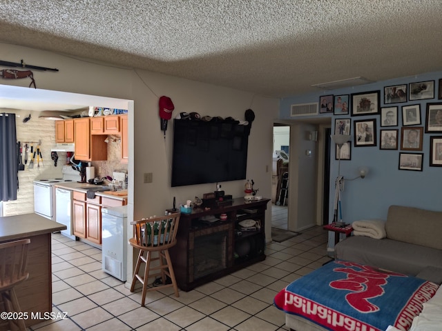 living room with light tile patterned flooring, sink, and a textured ceiling