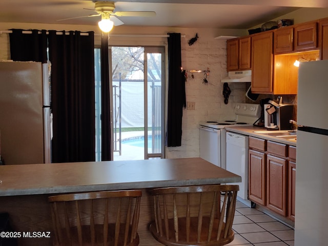 4016 E Fairmount St, Tucson, AZ 85712 - kitchen with light countertops, white appliances, light tile patterned floors, under cabinet range hood, and a ceiling fan