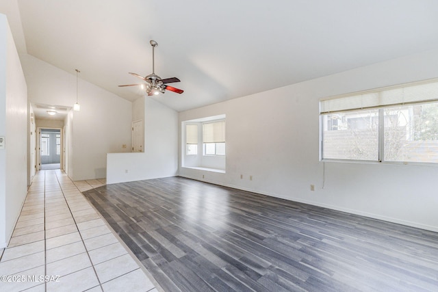 unfurnished living room featuring hardwood / wood-style flooring, ceiling fan, and vaulted ceiling