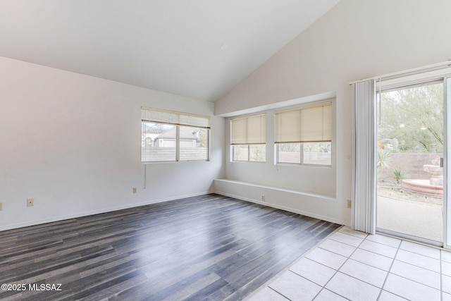 spare room with wood-type flooring, a wealth of natural light, and high vaulted ceiling