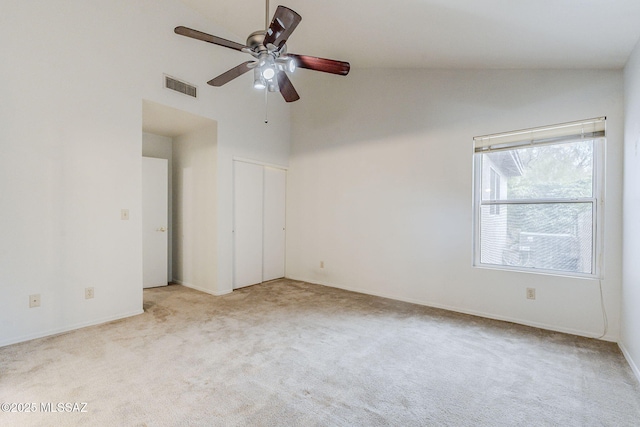 unfurnished bedroom with ceiling fan, light carpet, and high vaulted ceiling