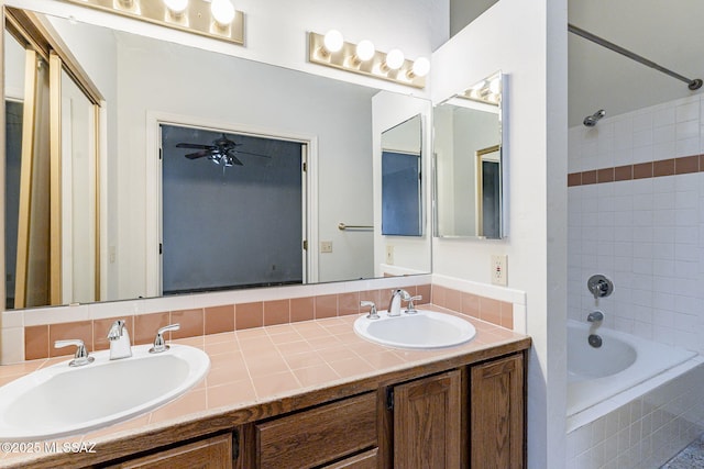 bathroom with tiled shower / bath and vanity