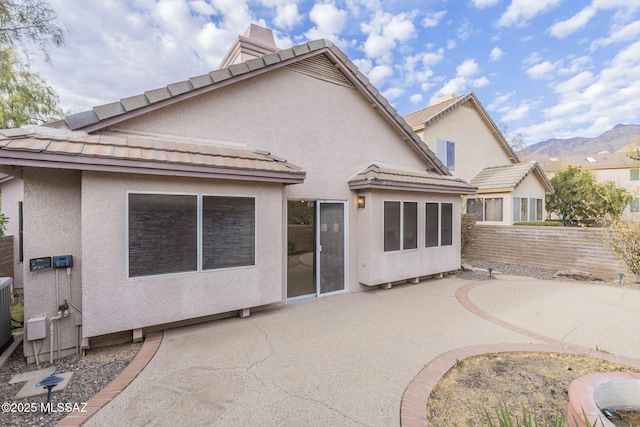 rear view of property featuring a mountain view and a patio area