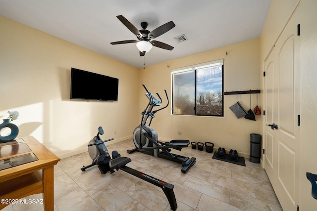 exercise room featuring light tile patterned floors and ceiling fan