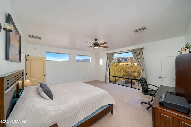 bedroom featuring ceiling fan, multiple windows, and light carpet