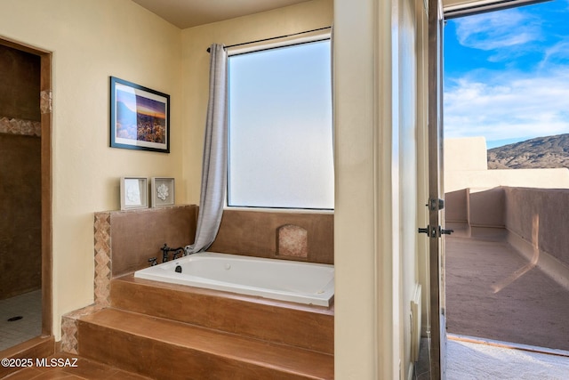 bathroom featuring a mountain view and independent shower and bath