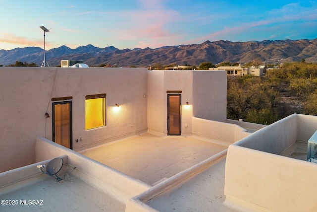 back house at dusk with a balcony and a mountain view