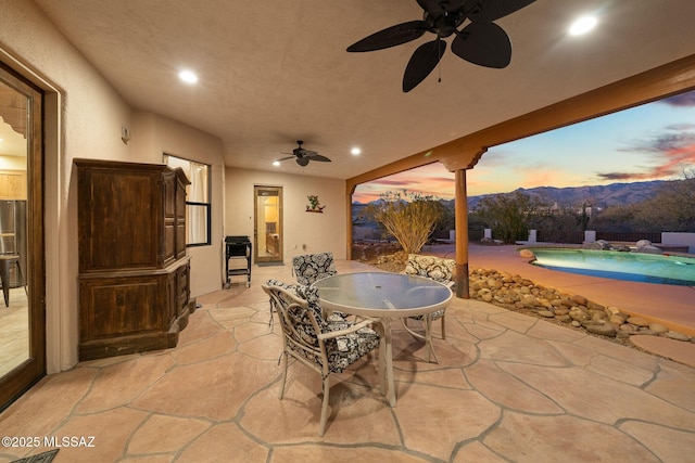 patio terrace at dusk with a mountain view and ceiling fan