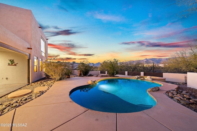 pool at dusk with a mountain view and a patio