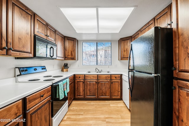 kitchen with sink, light wood-type flooring, and black appliances