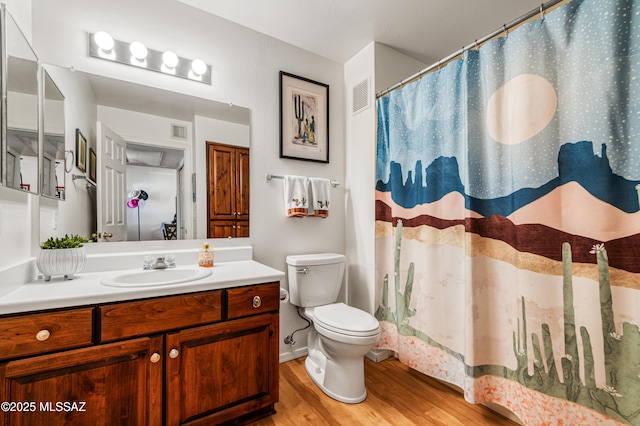 bathroom with walk in shower, vanity, toilet, and hardwood / wood-style floors