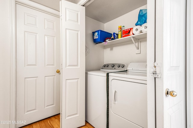 clothes washing area featuring washing machine and dryer and light hardwood / wood-style flooring