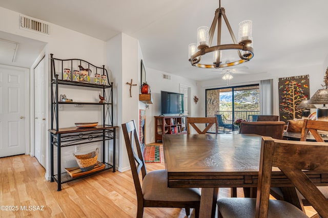 dining area with light hardwood / wood-style flooring and a chandelier