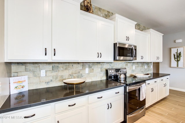 kitchen featuring appliances with stainless steel finishes, white cabinets, backsplash, and light hardwood / wood-style flooring