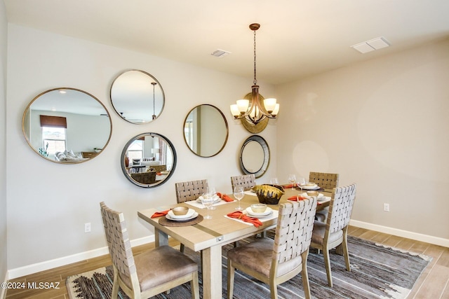 dining space with an inviting chandelier and wood-type flooring