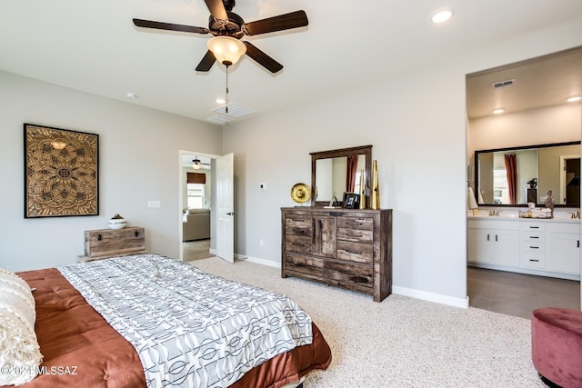 bedroom featuring ceiling fan, ensuite bathroom, and light carpet