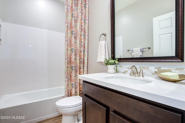 full bathroom featuring vanity, shower / bath combo with shower curtain, and toilet