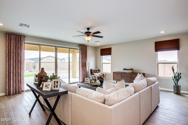 living room with light hardwood / wood-style flooring and ceiling fan