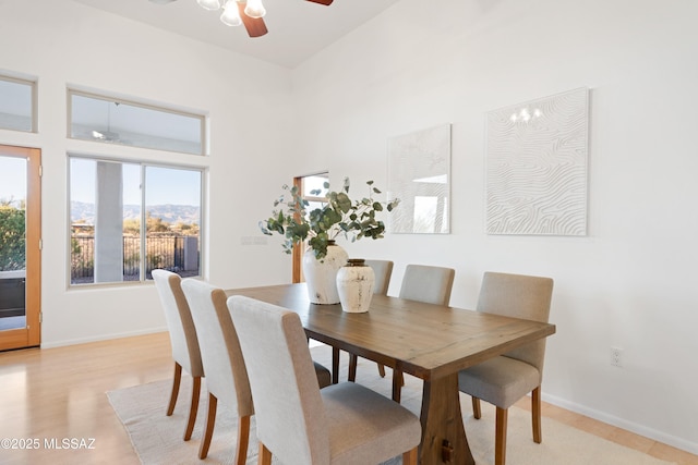 dining area with light wood-type flooring and ceiling fan