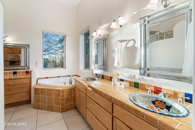 bathroom featuring tile patterned floors, vanity, and tiled tub