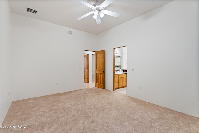 empty room with ceiling fan and light carpet