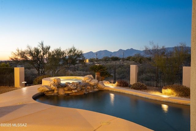 pool at dusk with a mountain view and a patio