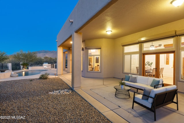 view of patio featuring a fenced in pool, an outdoor living space, and a mountain view