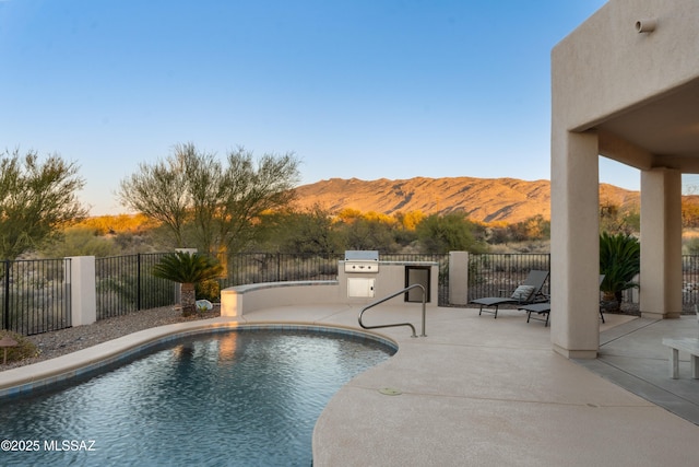 view of pool featuring area for grilling, a mountain view, and a patio area