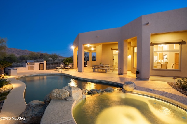 view of pool with area for grilling, a mountain view, and a patio area