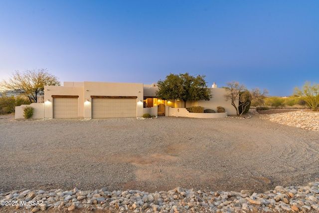 pueblo-style house featuring a garage