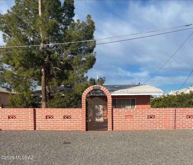 view of front of home with brick siding and fence