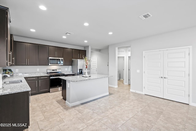 kitchen with a center island, visible vents, stainless steel appliances, and a sink