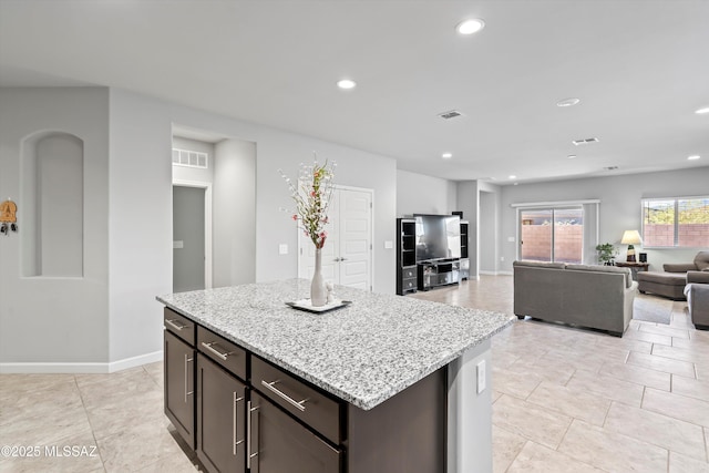 kitchen featuring recessed lighting, open floor plan, visible vents, and light stone counters