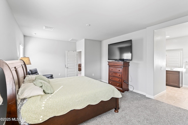 bedroom featuring visible vents, light colored carpet, connected bathroom, and baseboards