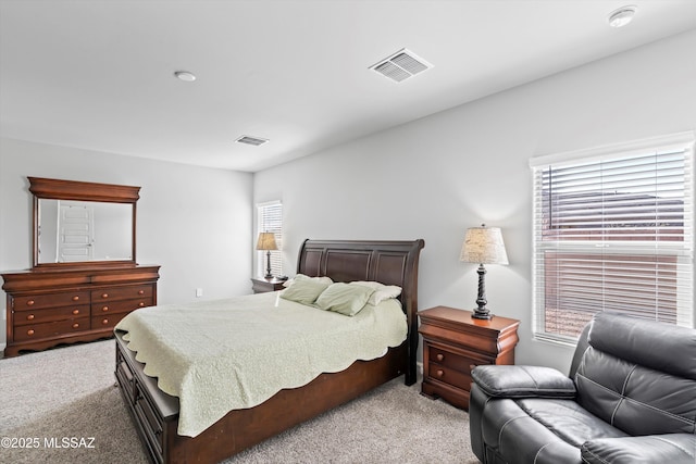 bedroom featuring visible vents and light colored carpet