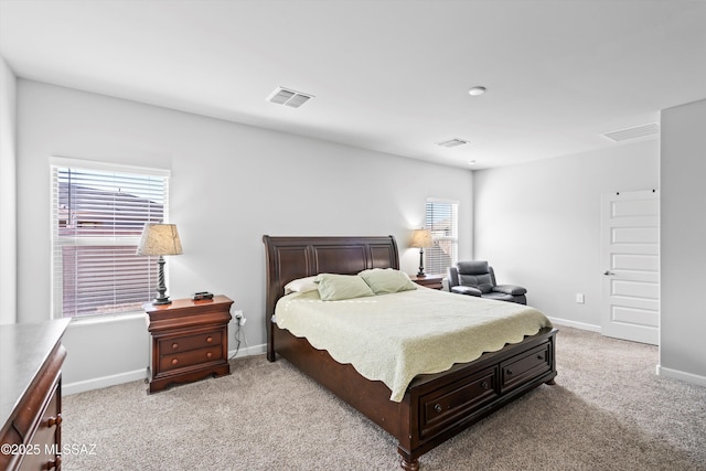 bedroom featuring visible vents, light colored carpet, and baseboards