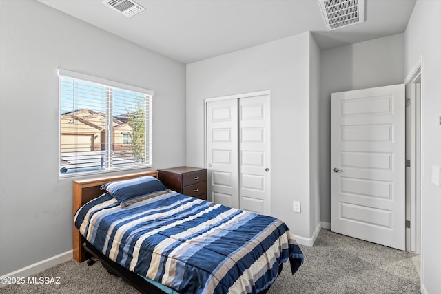 carpeted bedroom featuring a closet, visible vents, and baseboards