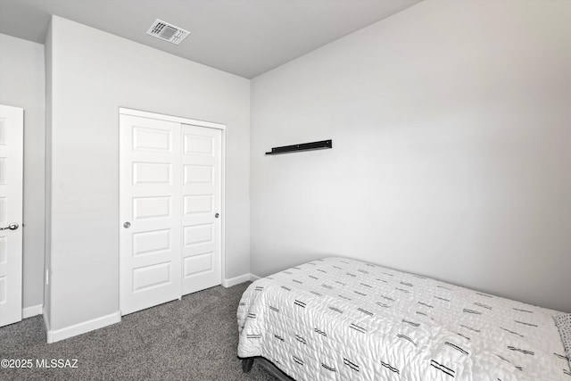 bedroom featuring dark carpet, visible vents, baseboards, and a closet