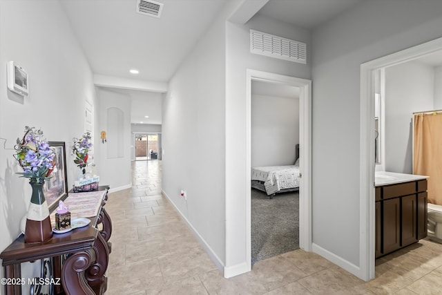 hallway with light tile patterned floors, visible vents, recessed lighting, and baseboards