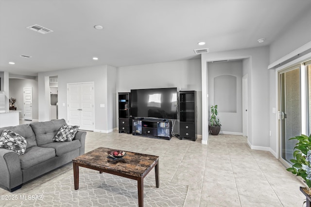 living area featuring light tile patterned flooring, recessed lighting, visible vents, and baseboards