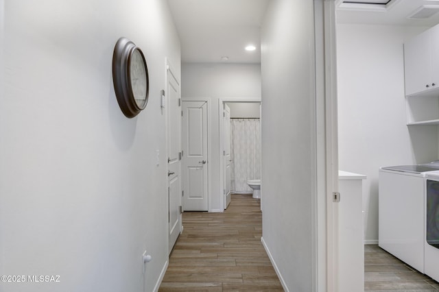 corridor featuring light hardwood / wood-style floors and independent washer and dryer