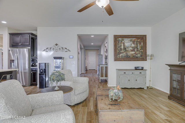 living room with ceiling fan and light wood-type flooring