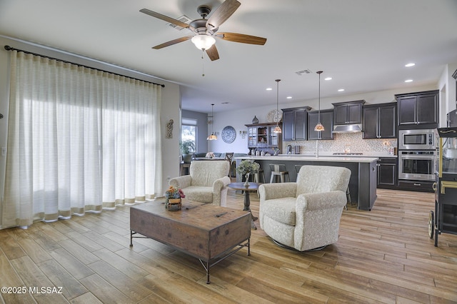 living room featuring ceiling fan and light hardwood / wood-style floors